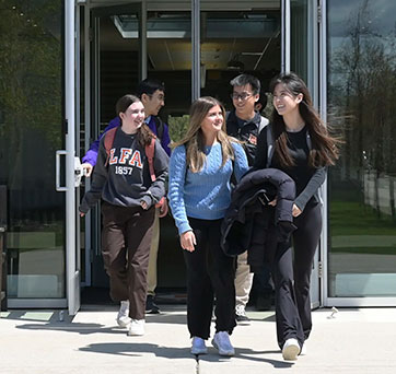 Students walking out a building. Links to Gifts of Real Estate