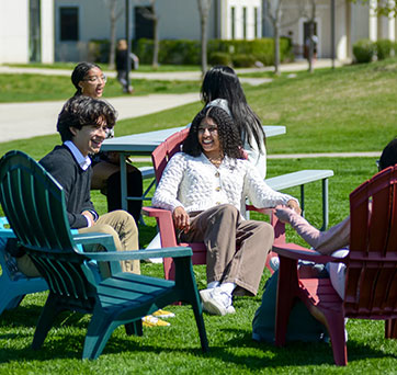 Students sitting outside. Links to Closely Held Business Stock